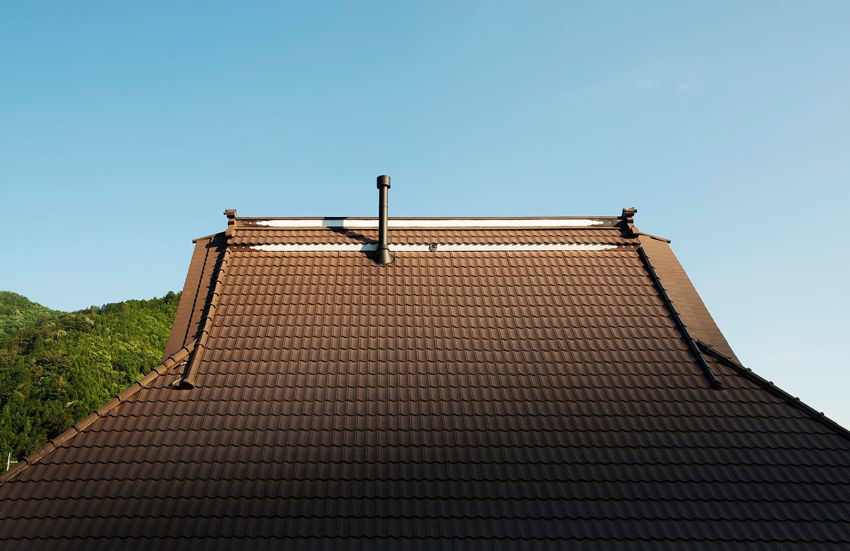 高い屋根が瓦で覆われたかやぶき古民家です。