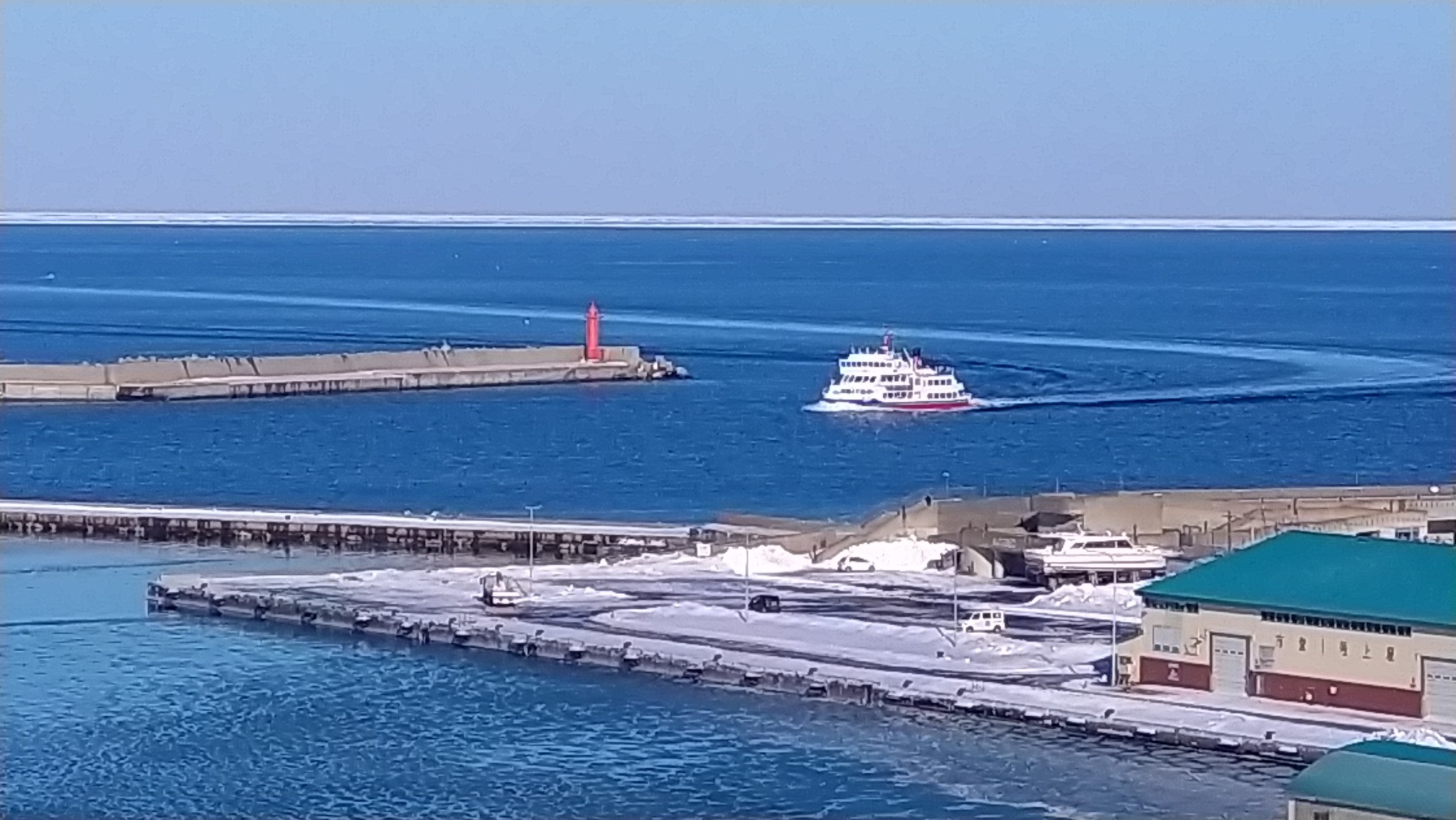 帰港するオーロラ。水平線に流氷が見える。